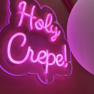 a neon sign that says holly crepe