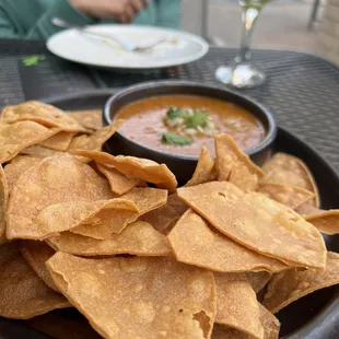 a plate of tortilla chips and a bowl of salsa