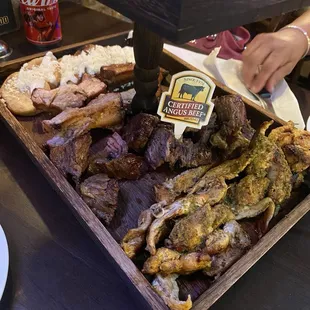 Photo of their Bandeja de Gloria. It has steak, chicken, pork ribs, little arepas, fried cheese, chorizo, and chicharrón