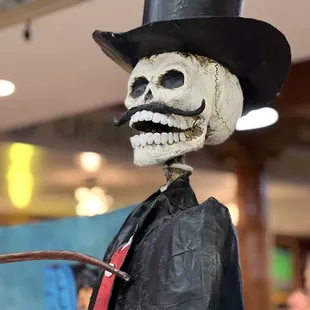 a skeleton wearing a top hat and tie