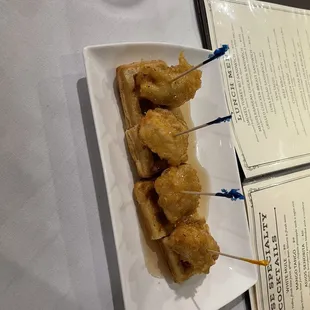 a plate of chicken skewers