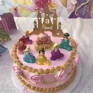 a cake with princess figurines on it