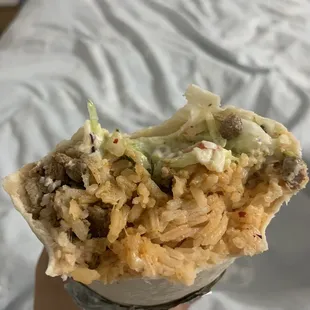 a hand holding a burrito