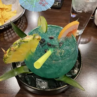 a blue drink with fruit garnish