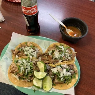 a plate of tacos and a bottle of coke
