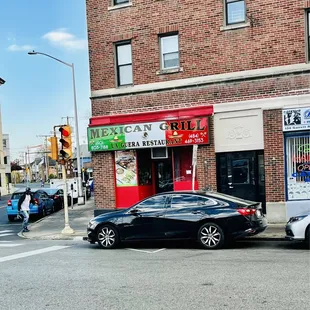 a black car parked in front of a restaurant