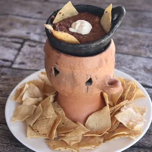 a clay pot filled with tortilla chips
