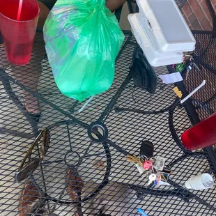 a woman sitting at a table covered in trash
