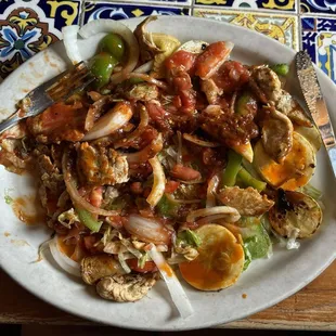 Chicken fajita with sautéed squash and a variety of veggies on a bed of lettuce.