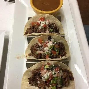 three tacos on a white plate