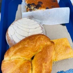 (front to back) croissant looking bread, cornbread, concha and bread pudding (it has raisins in it)