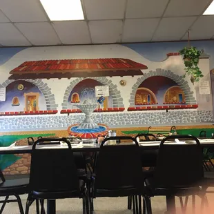 a dining room with a mural on the wall