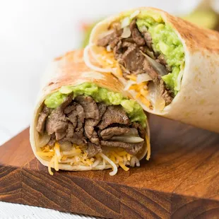 a burrito cut in half on a cutting board