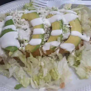 Flautas topped with lettuce, avocado, crema &amp; queso fresco..