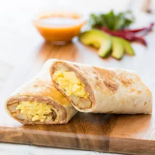 a breakfast burrito on a cutting board
