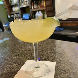 a margarita with a lime wedge