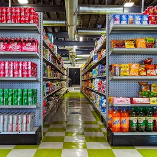 a supermarket aisle with shelves of sodas and drinks