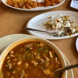 a bowl of soup and plates of food