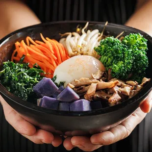 a person holding a bowl of food