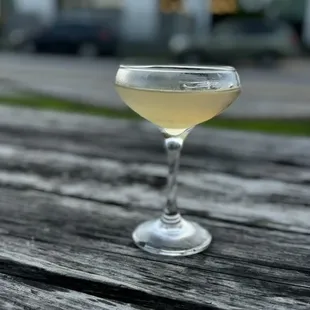 a glass of wine sitting on a wooden table