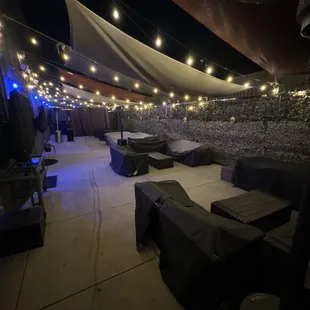 a view of a patio with tables and umbrellas