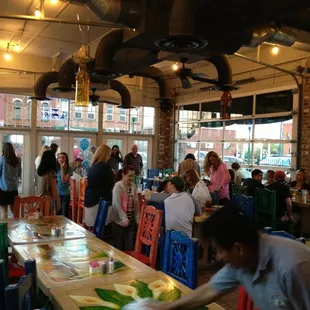 a large group of people sitting at tables in a restaurant