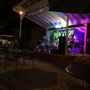 an outdoor bar with purple lighting