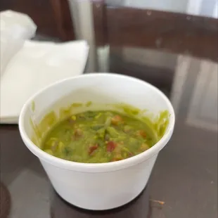 Side order of wrong guacamole less then half way. The bottom container is 3/4 inches up from the table.