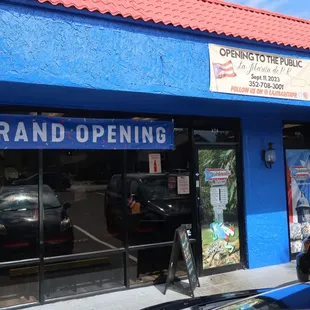 a blue building with a sign that says grand opening