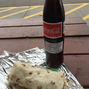 a bottle of coke and a burrito