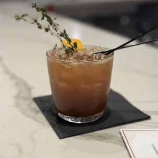 a glass of cocktail with a lemon garnish