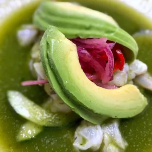 a green soup with avocado