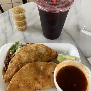 Quesabirria tacos with a side of consome and an agua de jamaica