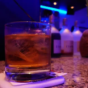 a drink in a glass on a coaster