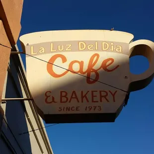 a cup of coffee hanging from the side of a building