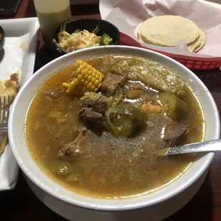 a bowl of soup and a plate of tortillas