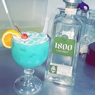 a blue cocktail with a cherry garnish