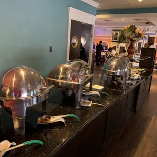 a long buffet table with a variety of food items