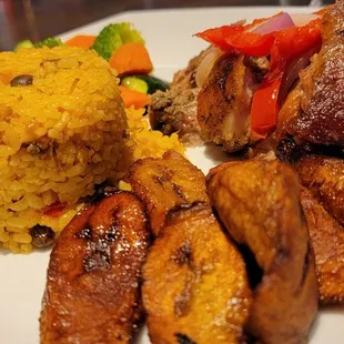 Pernil with yellow rice and plaintains.