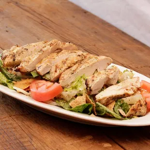 a chicken salad with tomatoes and lettuce