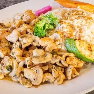 a plate of chicken, rice, and vegetables