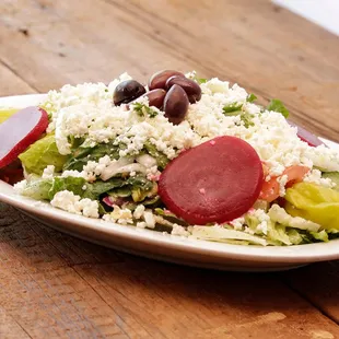 a plate of salad on a wooden table