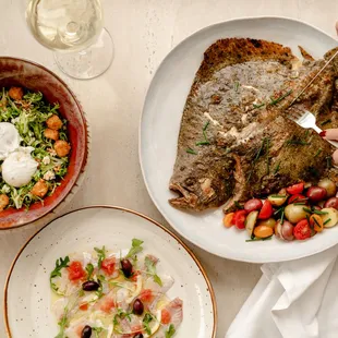 a plate of fish and a bowl of salad