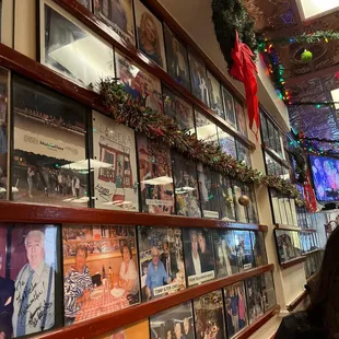 a woman looking at a wall full of pictures