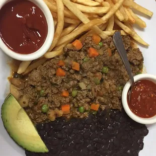 Picadillo de res con papas fritas y frijoles negros.