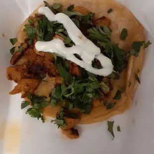 Al Pastor taco with sour cream and cilantro.