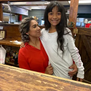 a woman and a young girl in a kitchen