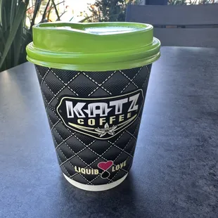 a coffee cup with a green lid