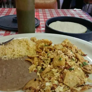 They serve their migas with onion, jalapeño and tomatoes. Got no tomatoes and added chorizo. Very tasty.