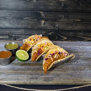 three tacos on a wooden table